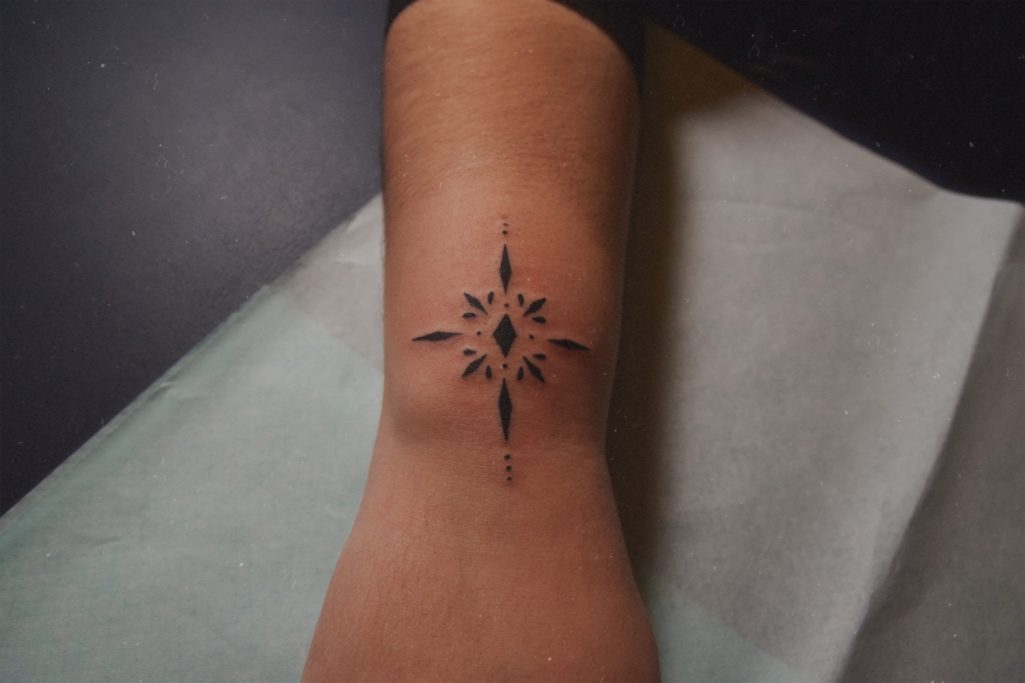 Tatouage ornemental sur l'avant-bras proche du poignet.