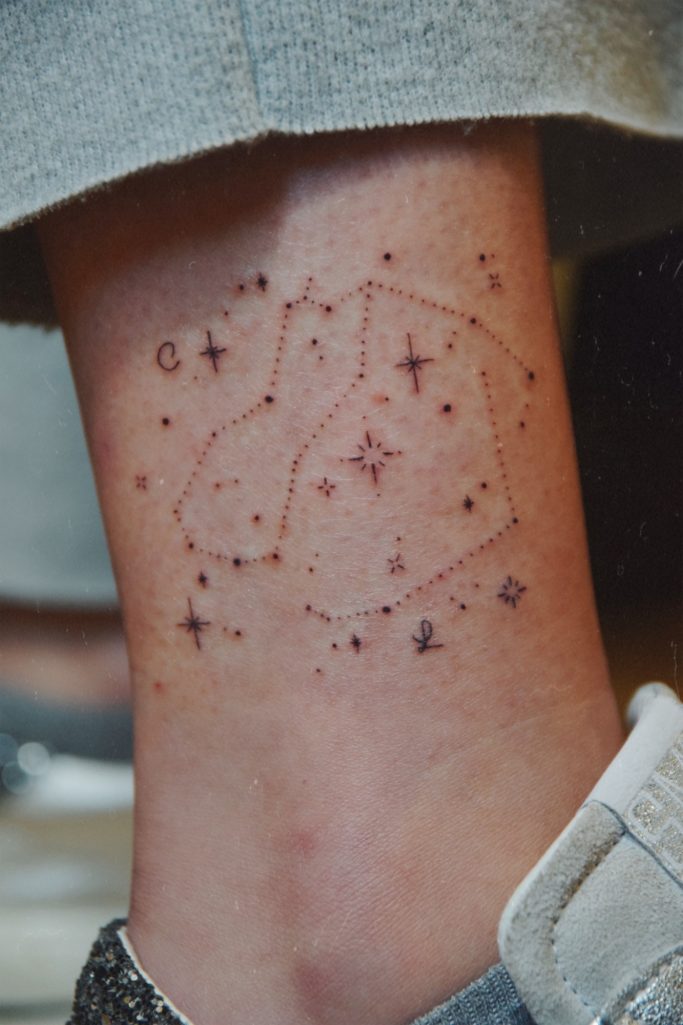 Tatouage représentant une constellation avec des étoiles sur une cheville.