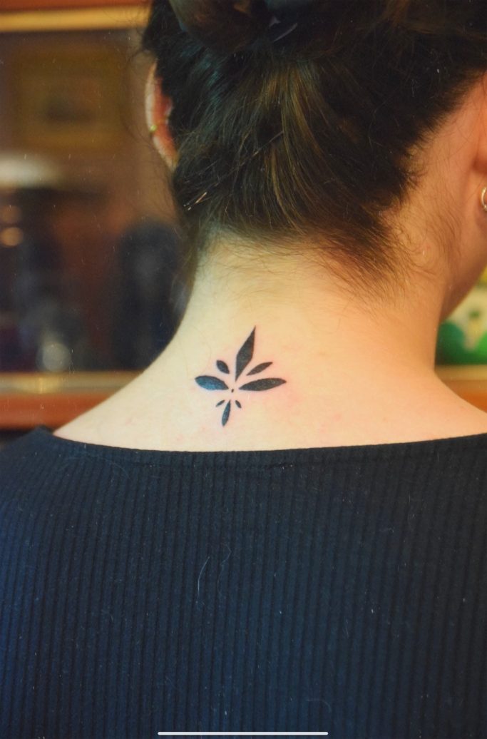 Tatouage de feuille sur la nuque d'une personne.