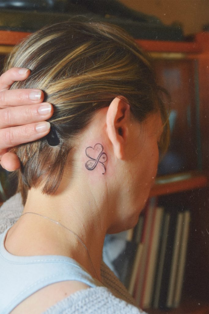 Tatouage de cœur infini derrière l'oreille.