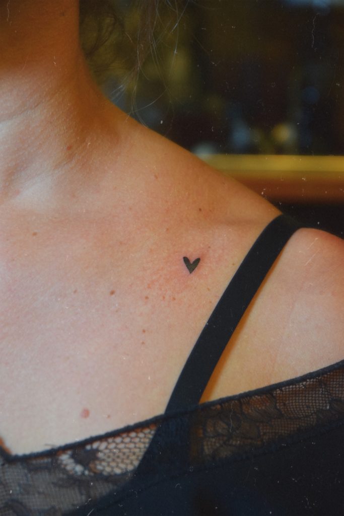Tatouage en forme de cœur sur l'épaule d'une personne.